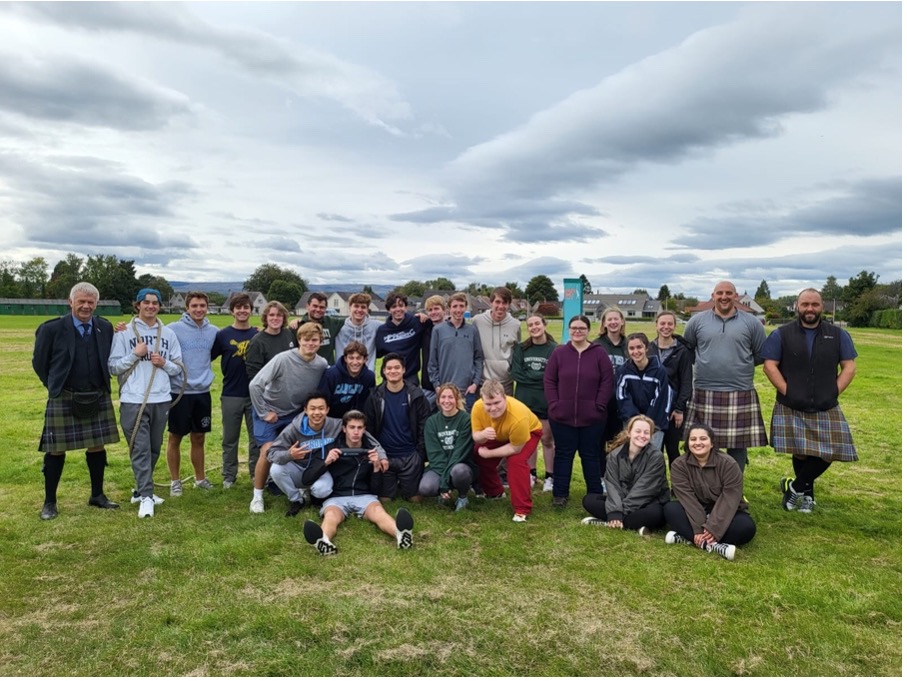A group of over twenty students stand close together, posing for a photo. 